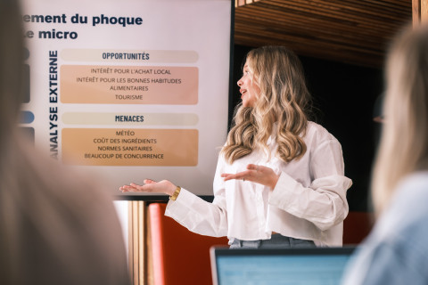 Une étudiante qui présente un projet en regardant un powerpoint