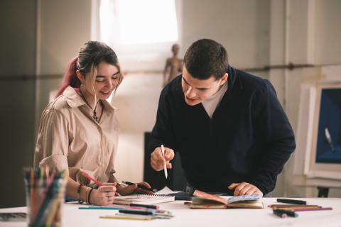 Une étudiante et un étudiant regarde un plan de travail
