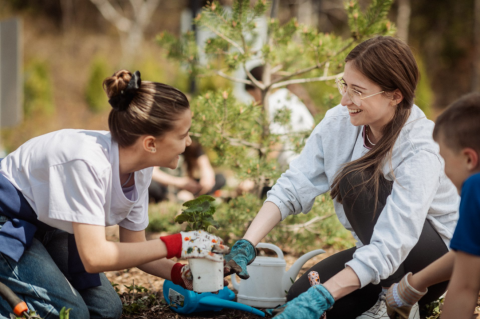 Une étudiante fait du jardinage avec une enfant