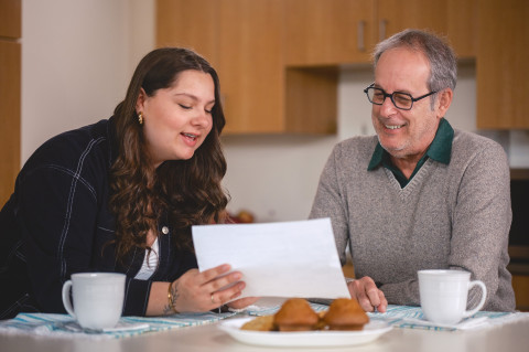 Une femme est assise à une table avec un homme et regarde un document