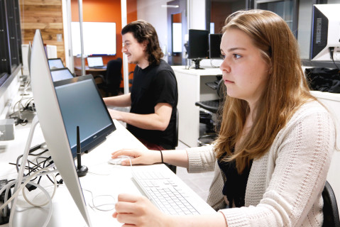 Un étudiant et une étudiante travaillent devant leur ordinateur