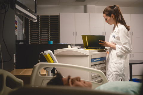 Une étudiante regarde le dossier médical du faux patient