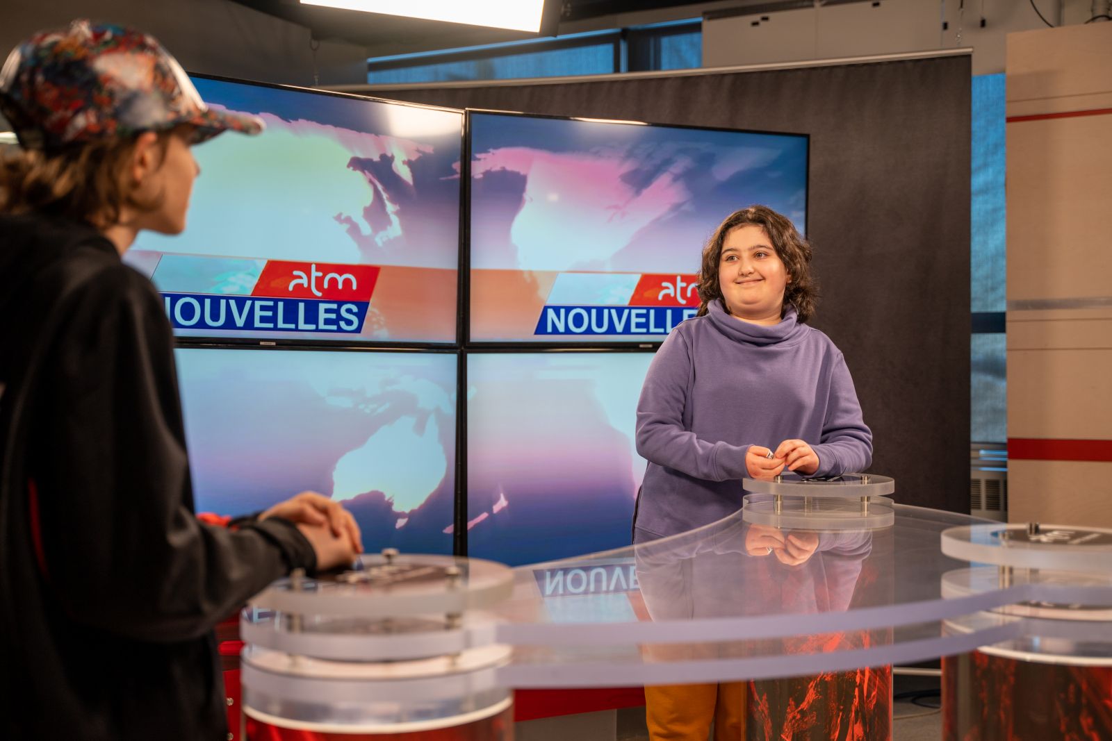 Deux adolescents discutent dans un studio de télévision.